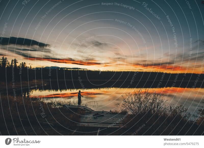 Kanada, Britisch-Kolumbien, Mann fischt am Duhu-See bei Sonnenuntergang angeln fischen angelt angelnd Männer männlich Seen Aussicht Ausblick Ansicht Überblick
