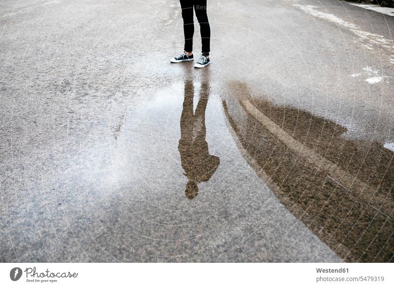 Reflexion eines Mannes in einer Pfütze auf dem Boden Böden Boeden Männer männlich Wasserspiegelung Wasserspiegelungen Pfützen Lache stehen stehend steht