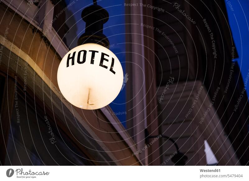 Beleuchtete Lampe mit dem Wort "Hotel" vor der Fassade bei Nacht Schweden Flachwinkelansicht von unten Froschperspektive Untersicht Symbolbild Symbolik