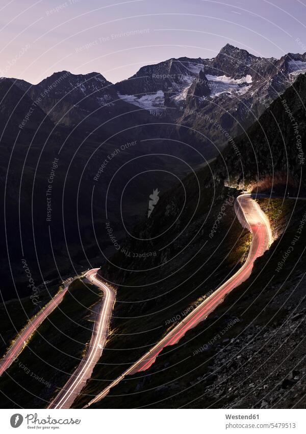 Hohe Winkelansicht von Lichtspuren auf Bergpass gegen Himmel in der Abenddämmerung, Südtirol, Italien Schönheit der Natur Bewegungsunschärfe Bewegungsunscharf