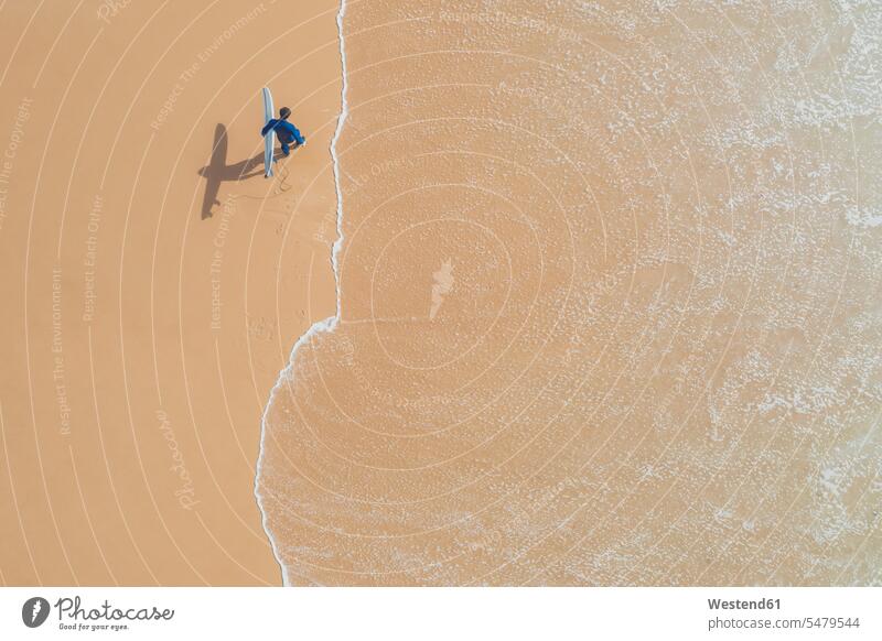 Portugal, Algarve, Sagres, Praia da Mareta, Luftaufnahme von Mann mit Surfbrett am Strand Sand sandig Drohne Drohnen Wasser alleine Wasserrand Surfen Surfing