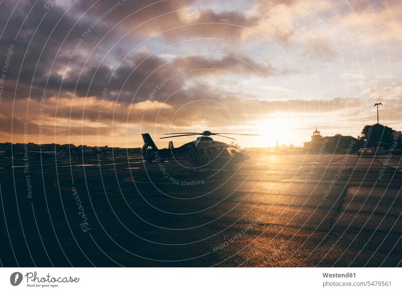 Hubschrauber auf dem Landeplatz bei Sonnenuntergang Helikopter Außenaufnahme draußen im Freien Gegenlicht Gegenlichtaufnahme Gegenlichtaufnahmen Abendlicht
