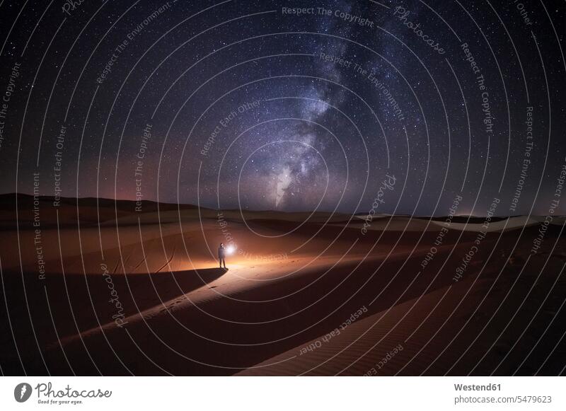 Marokko, Mann mit Licht bei Nacht in der Wüste Merzouga erkunden Erforschung Erkundung erforschen Sternhimmel Sternenhimmel nachts Orientierung orientieren