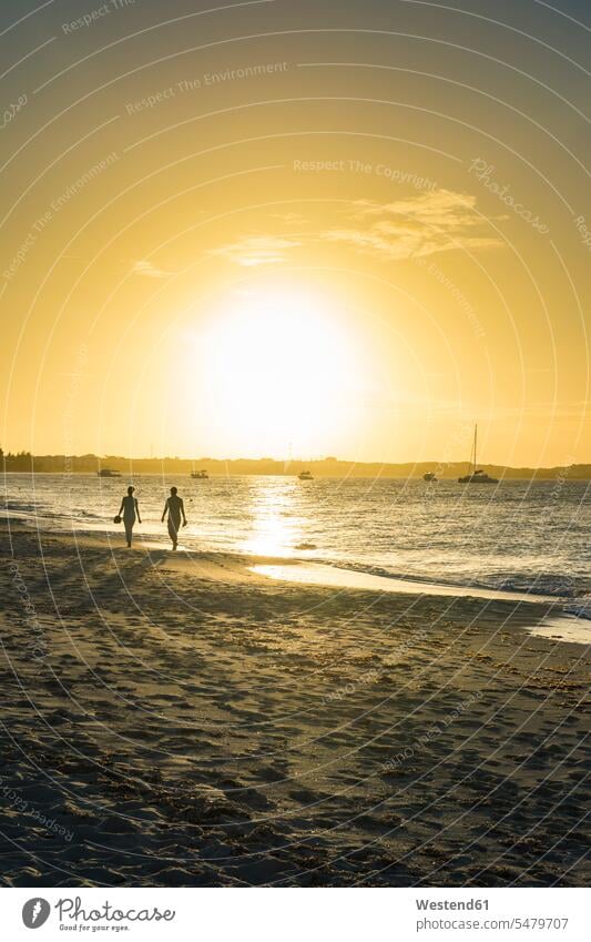 Silhouettenpaar beim Spaziergang am Strand von Grace Bay gegen den Himmel bei Sonnenuntergang, Providenciales, Turks- und Caicos-Inseln Abenteuer abenteuerlich