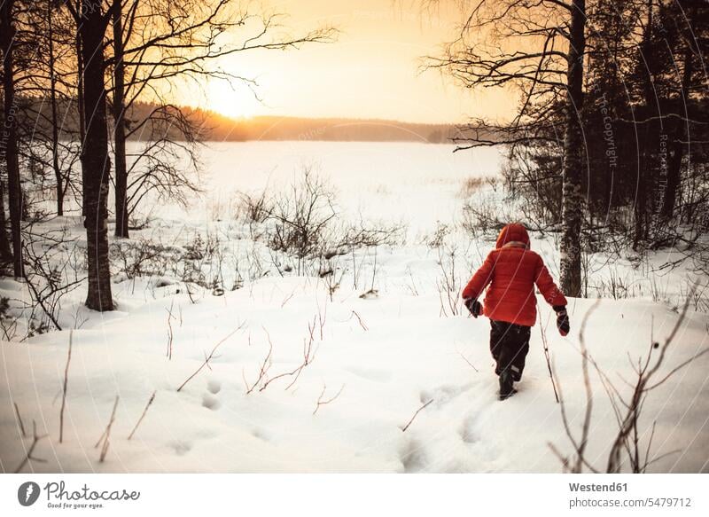 Finnland, Kuopio, Kleinkind Mädchen zu Fuß in Winterlandschaft bei Sonnenuntergang einsam zurueckgezogen vereinsamt zurückgezogen Handschuh Handschuhe
