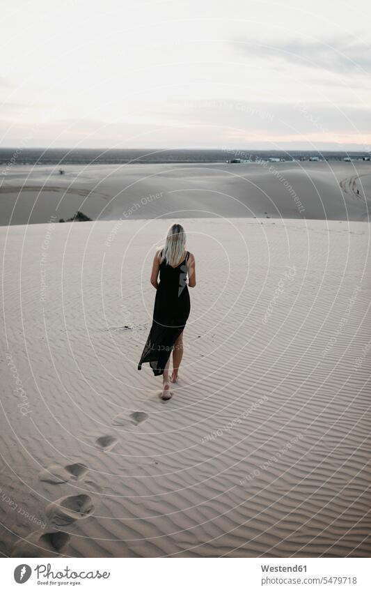 Rückenansicht einer blonden Frau, die auf einer Sanddüne geht, Algodones Dunes, Brawley, USA entspannen relaxen gehend Farben Farbtoene Farbton Farbtöne