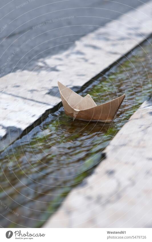 Frankreich, Papierboot schwimmt im Rinnstein Rinnsteine Gossen Abwesenheit abwesend menschenleer Sachaufnahme Sachaufnahmen Kindheit treiben treibend