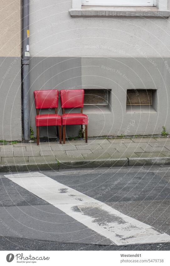 Zwei alte rote Stühle stehen nebeneinander auf dem Bürgersteig Stuehle Farben Farbtoene Farbton Farbtöne roter rotes stehend steht alter altes außen draußen