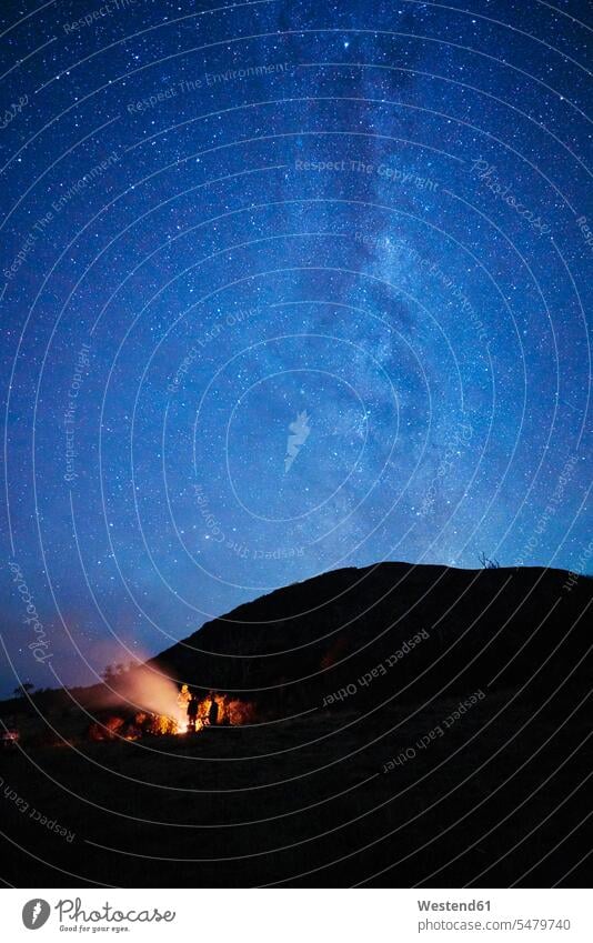 Chile, Feuerland, Lago Blanco, Menschen am Lagerfeuer unter Sternenhimmel bei Nacht nachts Sternhimmel Universum All Weltraum Weltall Kosmos Camping Campen
