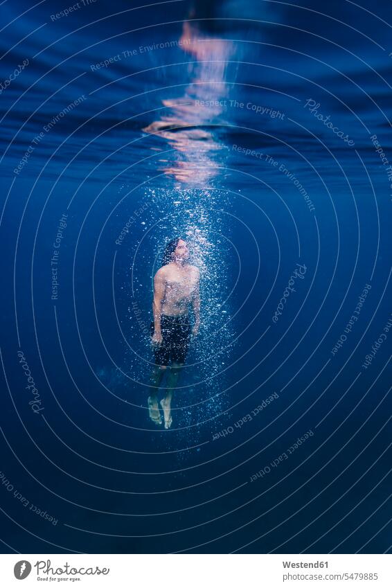Junger Mann taucht unter Wasser Luftblasen Muße auf Achse in Bewegung Abenteuer abenteuerlich Travel Unterwasseraufnahme Unterwasserfoto schwebend Taucher