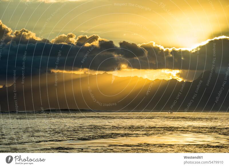 Französisch-Polynesien, Tahiti, Sonnenstrahlen brechen durch die Wolken über Moorea Weite Textfreiraum weit Silhouette Umriß Gegenlicht Schattenbilder