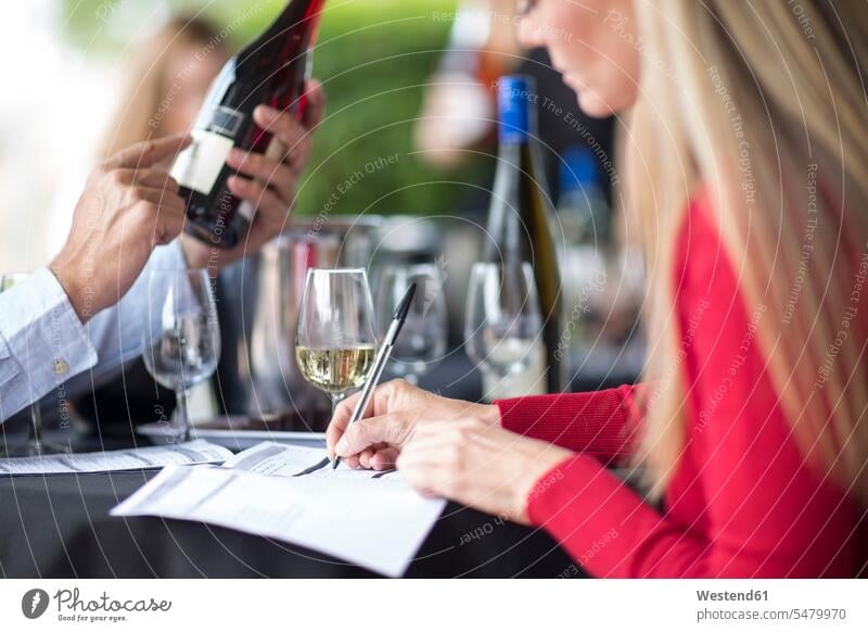 Mann und Frau probieren Wein und machen Notizen Weine notieren prüfen Kontrolle Untersuchung kontrollieren pruefen Restaurant Lokal Speiserestaurant Lokale