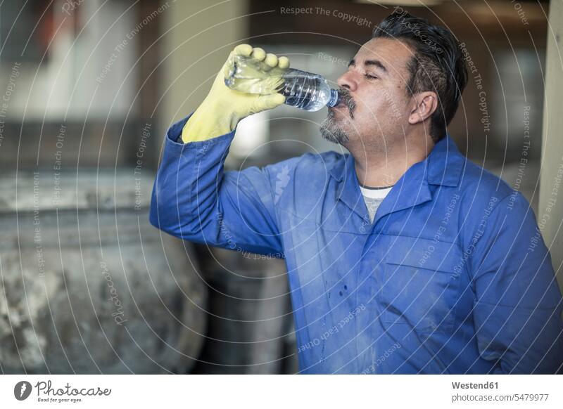 Arbeiter trinken Wasser aus der Flasche in einer industriellen Fabrik Fabriken Mann Männer männlich Erwachsener erwachsen Mensch Menschen Leute People Personen