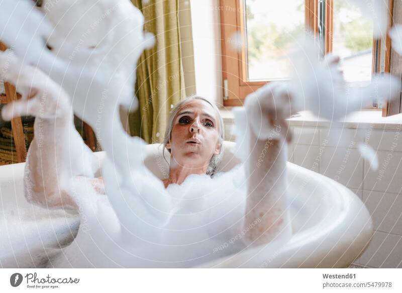 Porträt einer Frau in der Badewanne, die mit Schaumstoff spielt schaumig weiblich Frauen spielen Portrait Porträts Portraits Badewannen Erwachsener erwachsen
