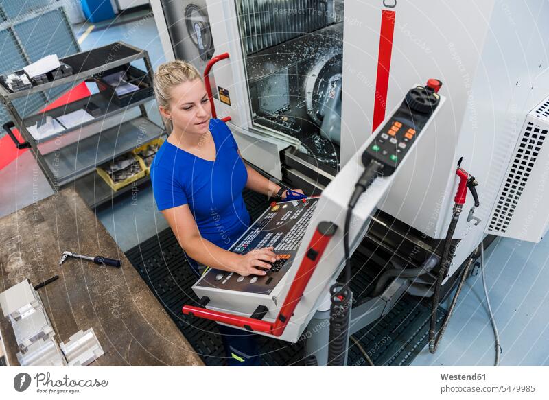 Frau bedient Bedienfeld in einer Industriefabrik Fabrik Fabriken weiblich Frauen arbeiten Arbeit Maschine Maschinen Erwachsener erwachsen Mensch Menschen Leute