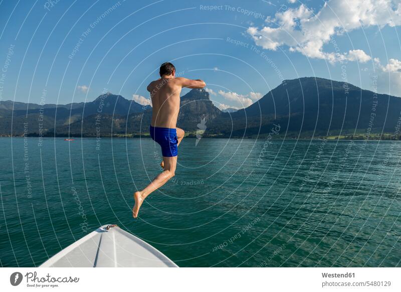 Österreich, Sankt Wolfgang, Mann springt vom Boot in den See Männer männlich Wasser springen hüpfen Seen Erwachsener erwachsen Mensch Menschen Leute People