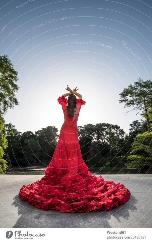 Rückenansicht einer in rot gekleideten Frau, die auf einer Terrasse Flamenco tanzt tanzen tanzend stehen stehend steht Tanz Kleid Kleider Tänzerin Taenzerin