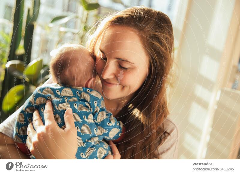 Mutter hält ihr Neugeborenes zu Hause Baby Babies Babys Saeugling Saeuglinge Säuglinge Kind Kinder lächeln Mami Mutti Mütter Mama Mensch Menschen Leute People