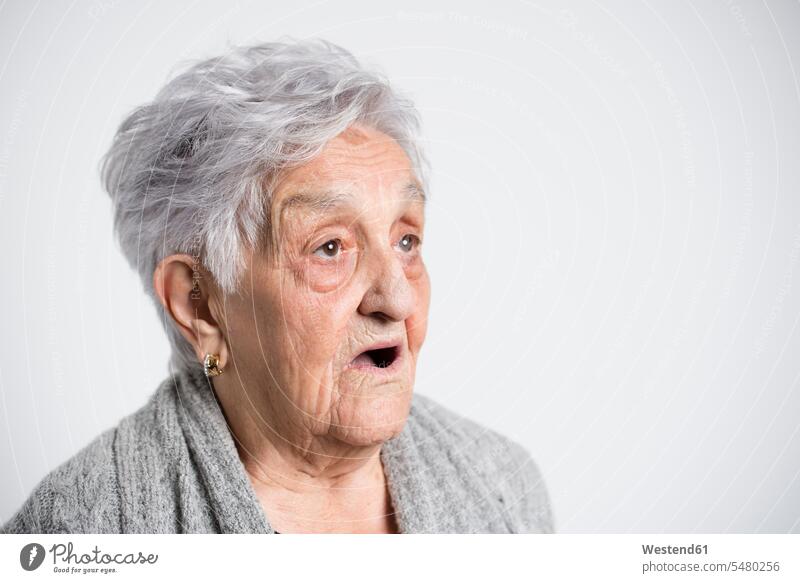 Porträt einer überraschten älteren Frau vor weißem Hintergrund Mimik Mienenspiel Gesichtsausdruck staunen erstaunen weißer Hintergrund weisser Hintergrund