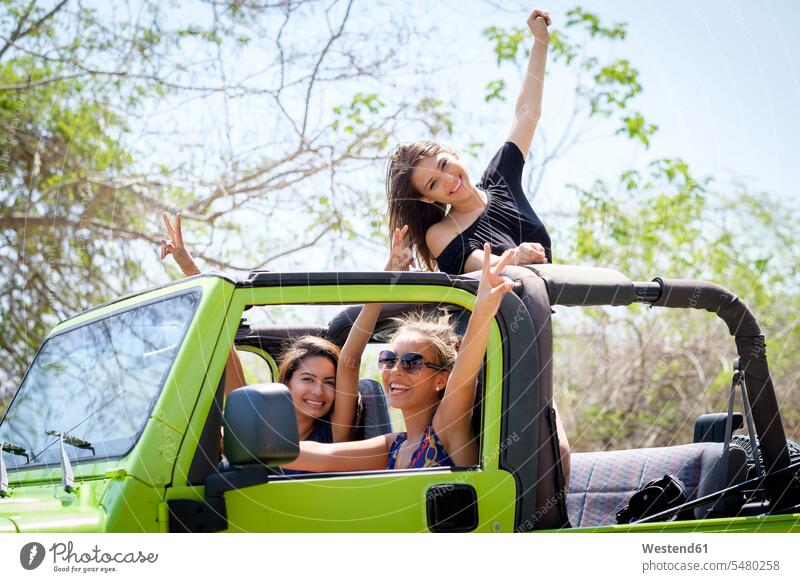 Drei Freunde haben Spaß im Geländewagen Freundinnen Geländefahrzeuge Jeep Jeeps Teenagerin junges Mädchen Teenagerinnen weiblich junge Frau Spass Späße spassig