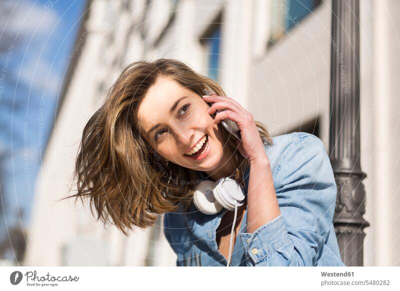 Porträt einer lachenden Frau mit Kopfhörer am Telefon weiblich Frauen telefonieren anrufen Anruf telephonieren Portrait Porträts Portraits Erwachsener erwachsen