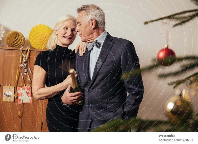Älteres Ehepaar hält Flasche Champagner am Vorabend von New Yera Deutschland Aktive Senioren Seniorinnen Aktiv im Alter Rüstige Rentner elegante Kleidung