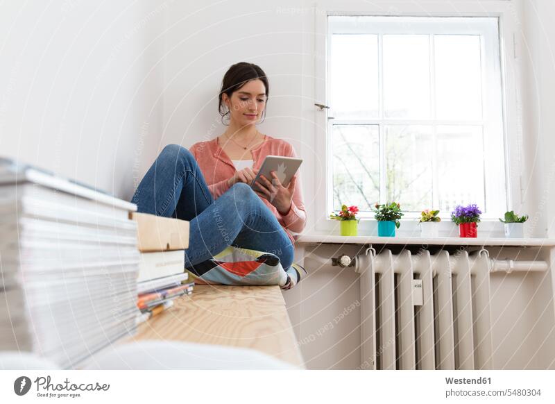 Junge Frau mit digitalem Tablett am Fenster Tablet Computer Tablet-PC Tablet PC iPad Tablet-Computer weiblich Frauen Rechner Erwachsener erwachsen Mensch
