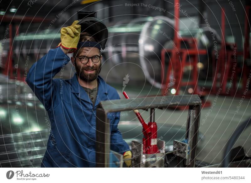 Porträt eines lächelnden Mannes mit einer Schweißermaske in einer Fabrik Männer männlich Schweißmaske Schweißhelm Arbeiter arbeiten Erwachsener erwachsen Mensch