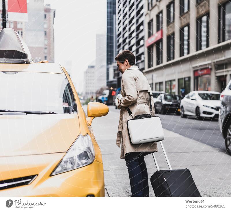 USA, New York City, Frau in Manhattan im Taxi New York State weiblich Frauen Taxis Taxen Koffer United States of America Vereinigte Staaten von Amerika