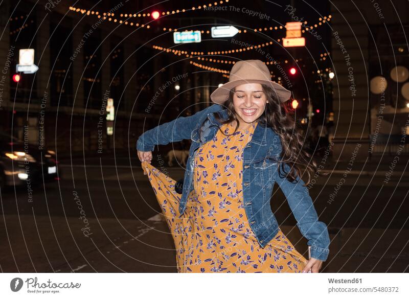 Glückliche junge Frau nachts auf der Straße lächeln Nacht tanzen tanzend weiblich Frauen Erwachsener erwachsen Mensch Menschen Leute People Personen Abend
