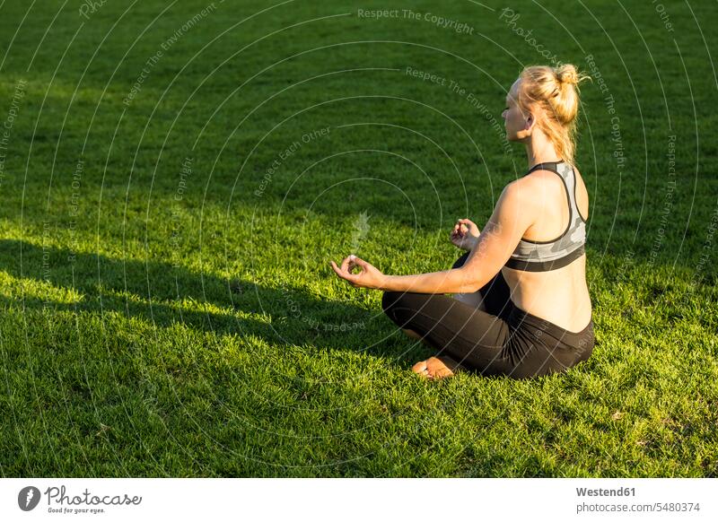 Frau macht Yoga im Park Übung Uebung Übungen Uebungen Yoga-Übungen Yogauebungen Yogaübungen Jogauebung Jogauebungen Parkanlagen Parks sitzen sitzend sitzt