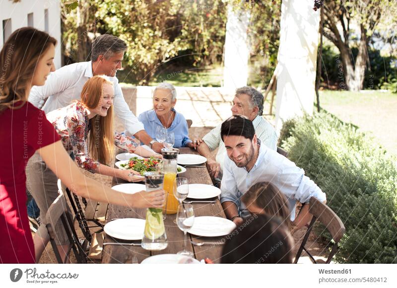 Glückliche Familie bereitet das Mittagessen auf dem Gartentisch vor feiern Spaß Spass Späße spassig Spässe spaßig glücklich glücklich sein glücklichsein