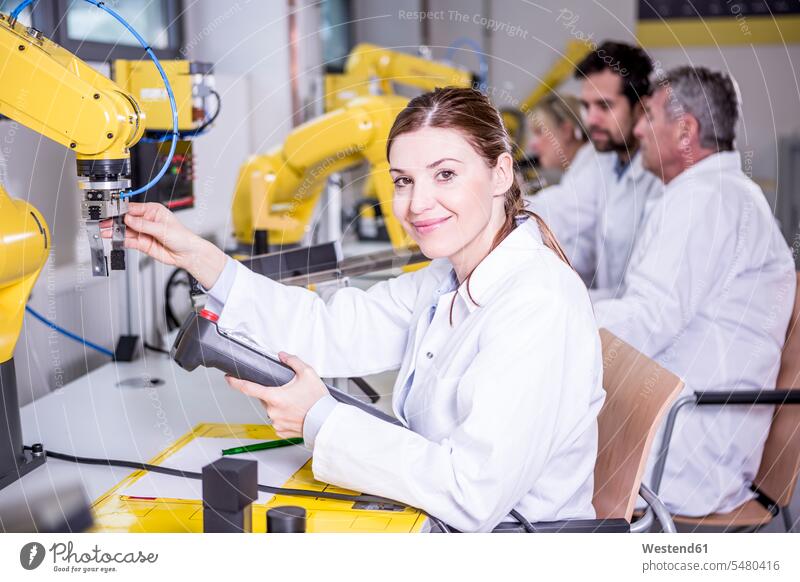 Porträt eines lächelnden Ingenieurs bei der Untersuchung eines Industrieroboters Ingenieure Roboter Fabrik Fabriken Technik Techniken Technologie industriell