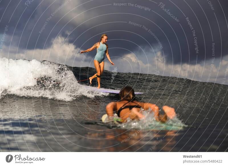 Indonesien, Bali, zwei Frauen beim Surfen Welle Wellen Surfing Wellenreiten Meer Meere weiblich Wasser Wassersport Sport Gewässer Erwachsener erwachsen Mensch