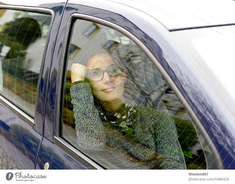 Frau schaut durch Autofenster Wagen PKWs Automobil Autos weiblich Frauen Kraftfahrzeug Verkehrsmittel KFZ Verkehrswesen Transportwesen Erwachsener erwachsen