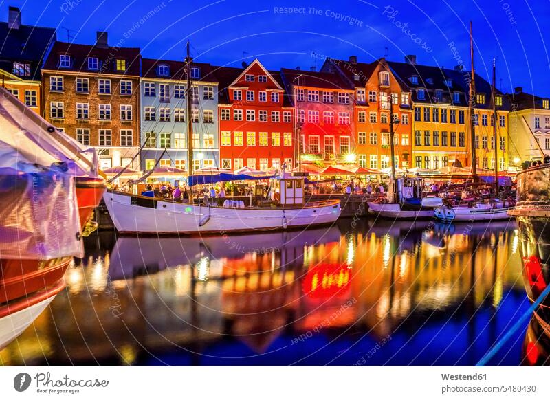 Dänemark, Kopenhagen, Blick auf historische Boote und Häuserzeile in Nyhavn am Abend vertäut vor Anker liegend angelegt ankern Stadtansicht Urban Stadtbilder