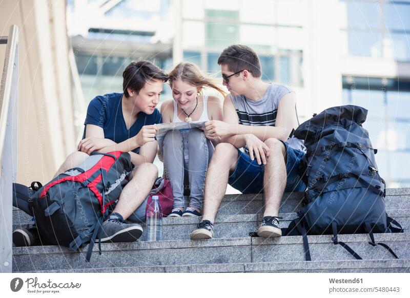 Junge Leute erkunden Berlin, Blick auf die Karte Reisende Reisender besichtigen Besichtigung Rucksacktourist Backpacker Stadtplan Stadtpläne Teenager