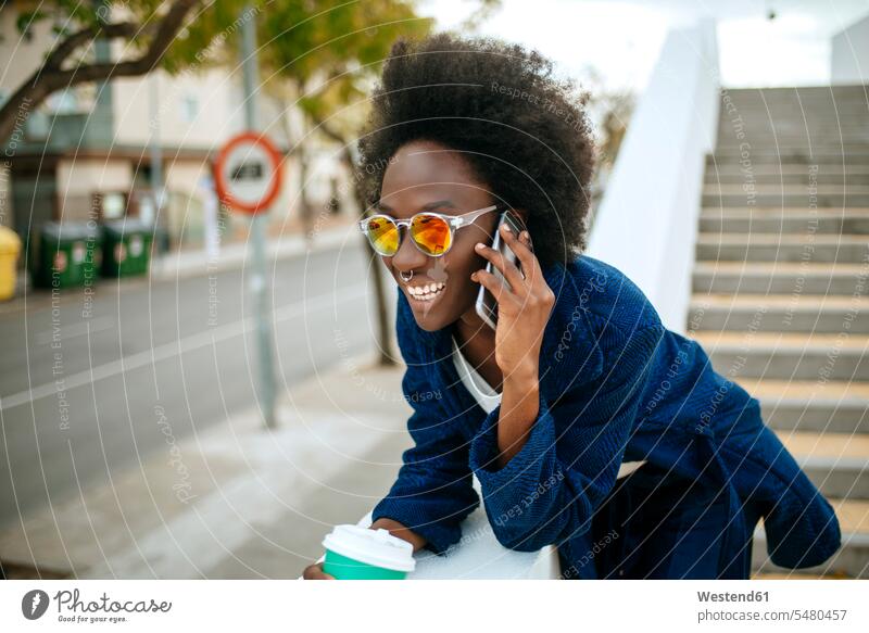 Porträt einer jungen Frau mit verspiegelter Sonnenbrille beim Telefonieren Spanien Coffee to go zum mitnehmen schön Smartphone iPhone Smartphones Seitenblick