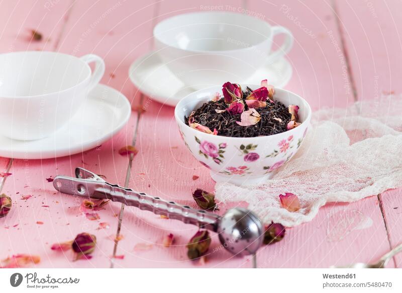 Schale schwarzer Tee mit getrockneten Rosenblüten Niemand Teetasse Teetassen Teesieb verstreut Stoff Gewebe Textilfasern Stoffe Schwarzer Tee Schwarztee