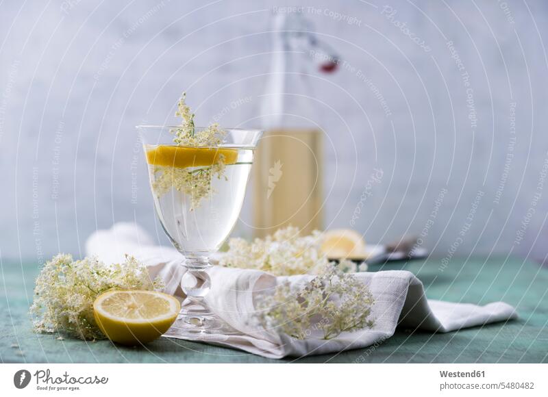Glas Wasser mit Holunderblütensirup und Zitrone aromatisiert Stoff Gewebe Textilfasern Stoffe Blüte Bluete Blueten Blütenkopf blühen Trinkgläser Gläser