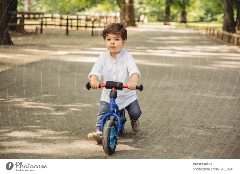 Kleinkind mit einem Balance-Fahrrad im Wildpark Kinderlaufrad Lauflernrad Lauflernräder Kinderlaufräder Junge Buben Knabe Jungen Knaben männlich Portrait