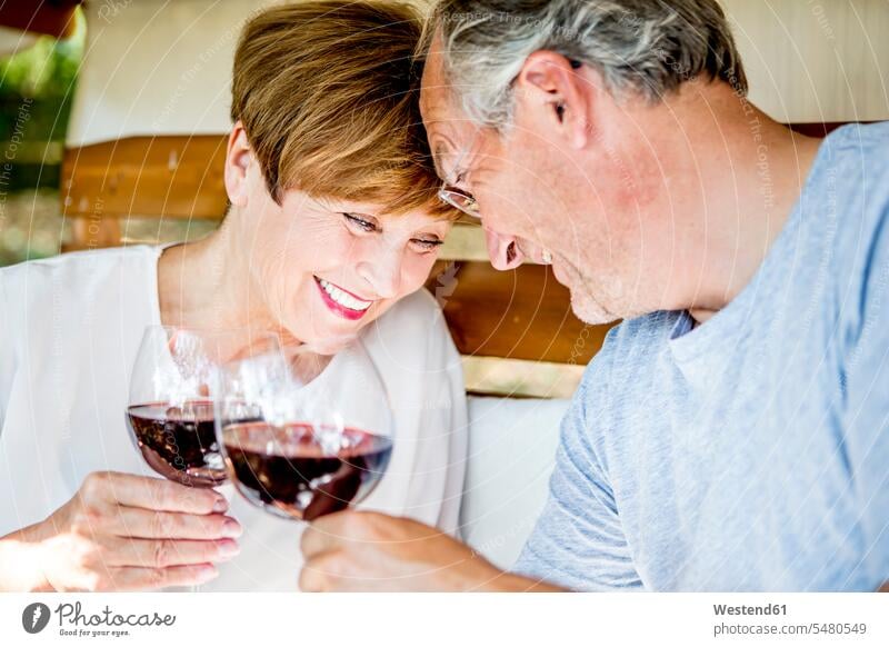 Glückliches älteres Ehepaar bei einem Glas Rotwein glücklich glücklich sein glücklichsein Paar Pärchen Paare Partnerschaft lächeln Wein Weine Mensch Menschen