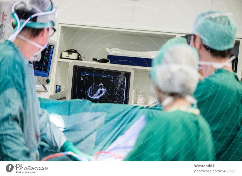Herzchirurgen und OP-Schwester schauen auf den Monitor Arzt Doktoren Ärzte Operation Operationen operieren Chirurgie Medizin medizinisch Gesundheitswesen