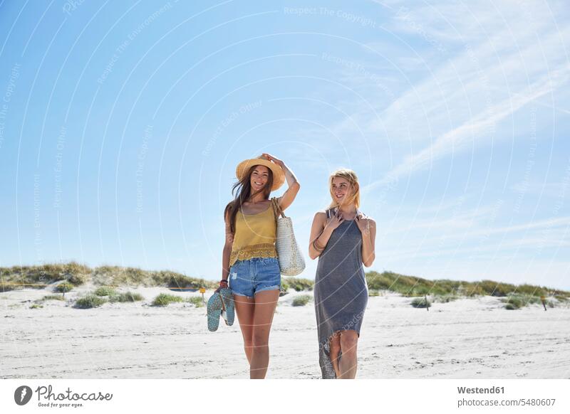 Zwei Freundinnen am Strand lächeln Frau weiblich Frauen Urlaub Ferien Beach Straende Strände Beaches Freunde Freundschaft Kameradschaft Erwachsener erwachsen