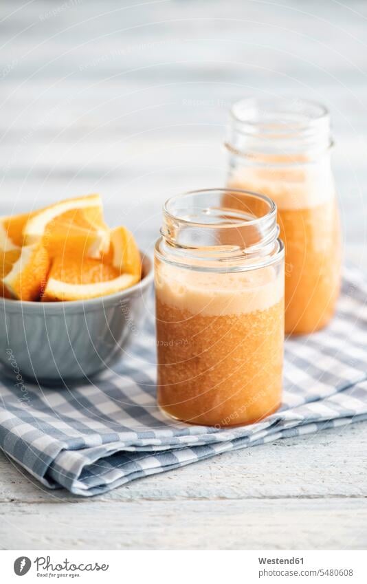 Orangen-, Karotten-, Ananas-, Ingwer-Smoothie in Gläsern Glas Fruchtsmoothie Küchentuch Smoothies Orangenscheibe Orangenscheiben Lifestyle Lebensstil