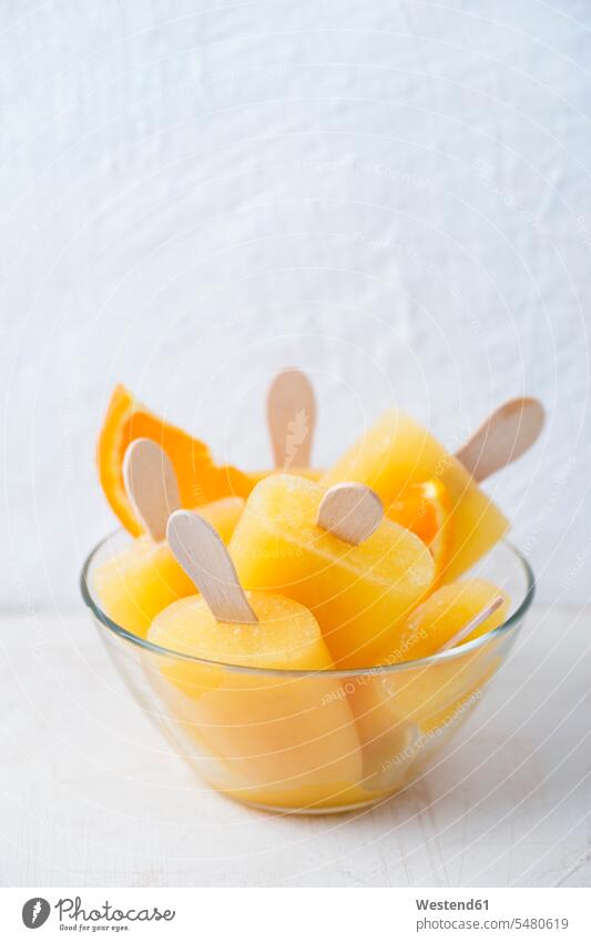 Glasschale mit hausgemachten orangefarbenen Eis am Stiel Schüssel Schalen Schälchen Schüsseln gefroren vereist eingefroren zugefroren übereinander auf obenauf