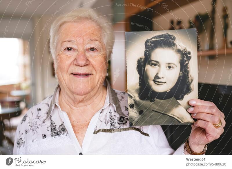 Porträt einer älteren Frau, die ein altes Bild von sich zeigt Europäer Kaukasier Europäisch kaukasisch Wohnzimmer Wohnraum Wohnung Wohnen Wohnräume Wohnungen