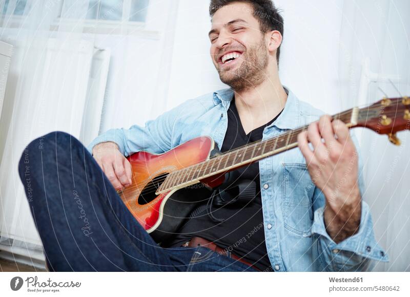 Glücklicher junger Mann spielt Gitarre Akustikgitarre Klassische Gitarre Klassische Gitarren Akustikgitarren Hobby Hobbies Freizeitkleidung casual