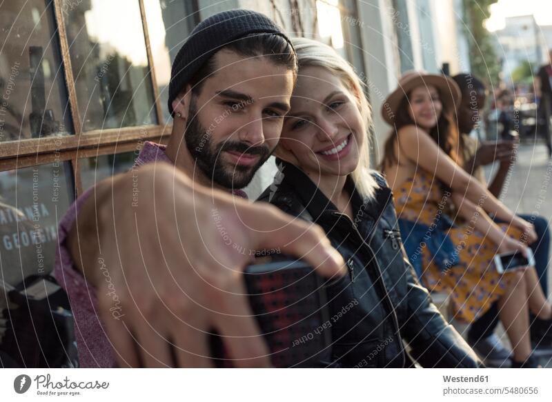 Junger Mann mit Freundin macht ein Selfie lächeln Selfies Handy Mobiltelefon Handies Handys Mobiltelefone Paar Pärchen Paare Partnerschaft Mensch Menschen Leute