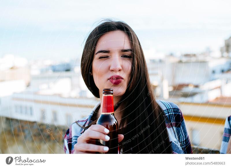 Spanien, Jerez de la Frontera, Porträt einer zwinkernden jungen Frau mit Bierflaschenschmollmund Europäer Kaukasier Europäisch kaukasisch entspannt